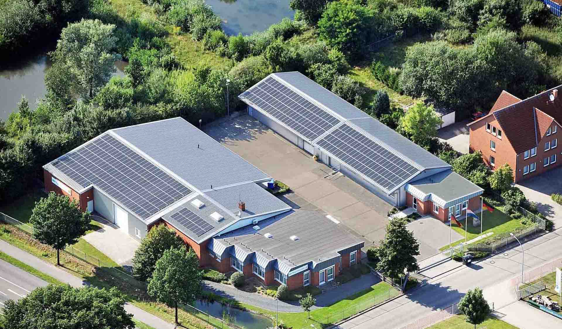 Luftaufnahme eines Industrie- und Logistikgebäudekomplexes mit Solarpaneelen auf den Hallendächern